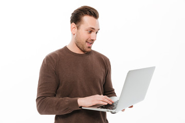 Excited young man using laptop computer.