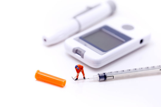 Miniature people : Worker with Diabetes blood glucose test on  isolated , healthcare concept.