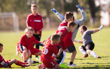 Fototapeta premium Kids soccer football - children players celebrating after victory