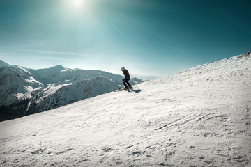 Naklejka na ściany i meble Nice mountains view at sunny day with skiers under blue sky with