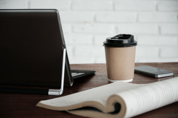 hot coffee cup on wooden table,blank coffee cup paper for insert text and graphics object,take away coffee cup mock up.