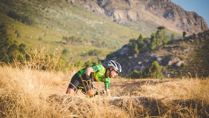 Wide angle view of a mountain biker speeding downhill on a mountain bike track in the woods