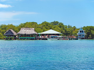 Tropical restaurant overwater with boats and tourists, Caribbean sea, Cayo coral, Bocas del Toro, Panama, Central America