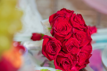 Red wedding bouquet of flowers . Wedding bouquet with pearls and red tapes . Wedding bouquet made of red Roses and Carnation flowers . Selective focus.