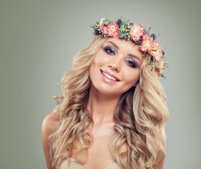 Smiling Blonde Woman Fashion Model in Rose Flowers Wreath. Beautiful Model with Blonde Curly Hairstyle