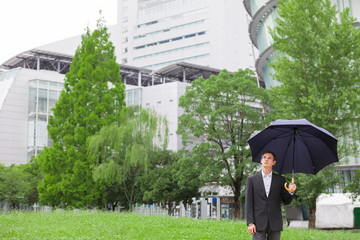 Young male caucasian holding umbrella.