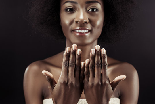 beautiful african american woman showing her nails isolated on black
