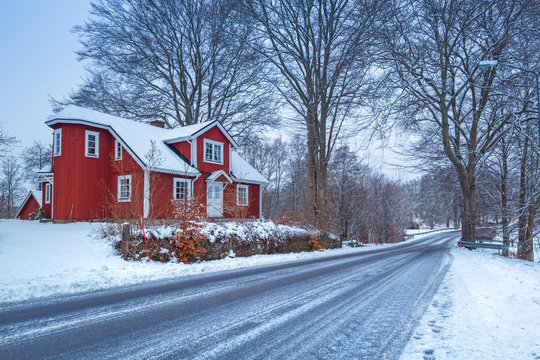 Winter scenery with red wooden house in Sweden
