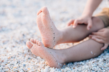 Feet of a child on the sand beach