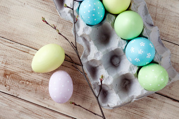 Rustic easter border on wooden background with yellow, pink, green and blue colored eggs in box. Easter. Orthodox holiday. Wooden background.