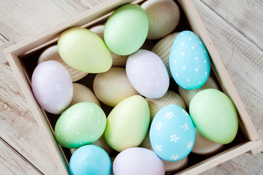 Easter eggs in a basket on rustic wooden background, selective focus image, Happy Easter!