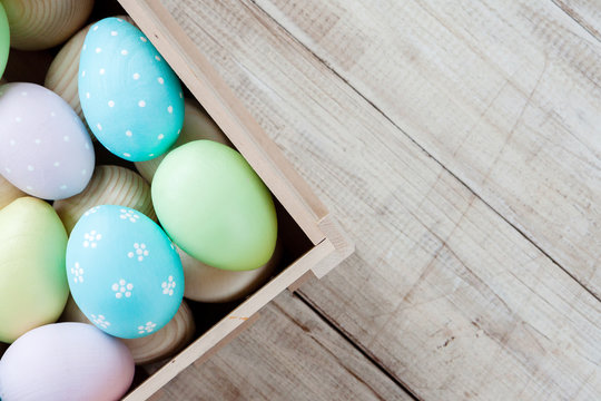 Easter eggs in a basket on rustic wooden background, selective focus image, Happy Easter. Space for text.
