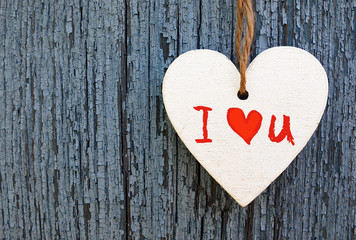 Valentines Day holiday background.
Decorative white wooden heart with I love You inscription on a blue wooden background.I Love You,St Valentine's Day or Love concept.Selective focus.