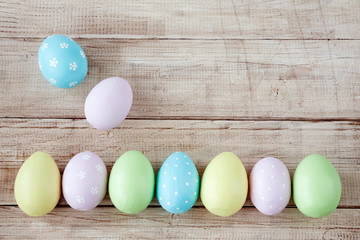 Easter eggs painted in pastel colors on wooden background. Pastel, hand painted Easter eggs. Top view with copy space. Orthodox holiday.