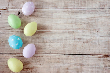 Easter eggs painted in pastel colors on wooden background. Pastel, hand painted Easter eggs. Top view with copy space. Orthodox holiday..