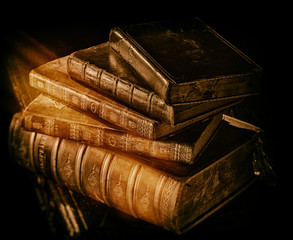 Old books stack in directional light and light leak.