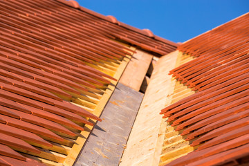 A roof under construction with stacks of roof tiles ready to fasten