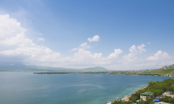 View from the monastery of Sevanavank to the city of Sevan. Lake Sevan, mountains, blue sky with clouds and horizon. Armenia.