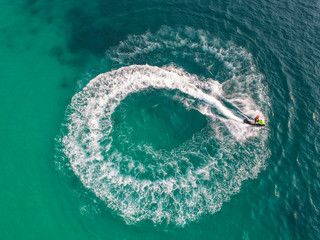 People are playing a jet ski in the sea.Aerial view. Top view.amazing nature background.The color of the water and beautifully bright. Fresh freedom. Adventure day.clear turquoise at tropical beach.
