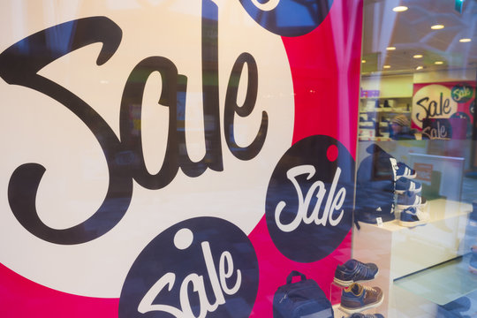 big letters indicate sale in shop windows of shoe store