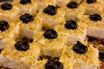 Turkish dessert with black chocolate and white cream. Sliced cake.