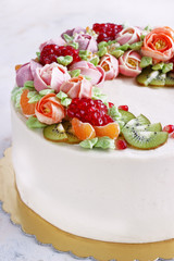 Festive cake with cream flowers and fruits on a light background