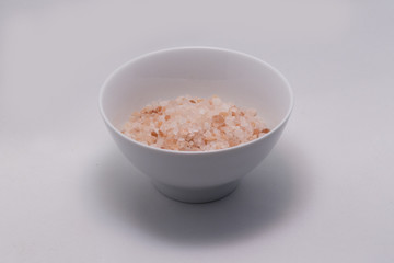 Himalayan salt in white bowl on white background isolated. Healthy lifestyle. 