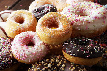 assorted donuts with chocolate frosted, pink glazed and sprinkles donuts.