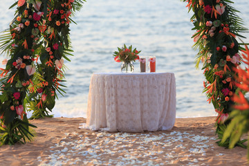 Beautiful setting wedding arch decorated with tropical flower on the beach. Out door tropical...