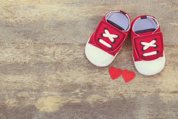Portrait of cute shoes and couple heart-shaped on wooden table background. Valentine and design concept.
