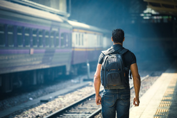 Fototapeta premium Young traveler walking with backpack on train station in thailand