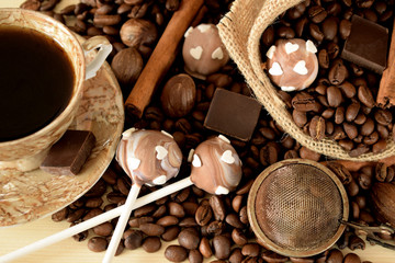 Cake pops with coffee glazing, coffee beans, chocolate pieces and cinnamon sticks