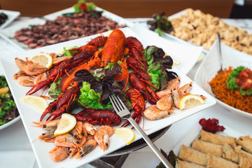 Fine selection of crustacean for dinner. Lobster, crab and jumbo shrimp on a white plate