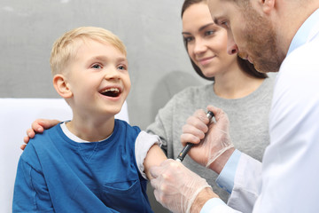 Lekarz podaje dziecku insulinę w zastrzyku. Dziecko chore na cukrzycę podczas  podawania zastrzyku z insuliny. - obrazy, fototapety, plakaty