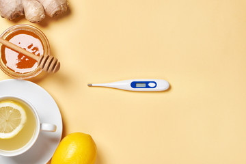 Fresh ginger root, lemon, honey, tea and thermometer
