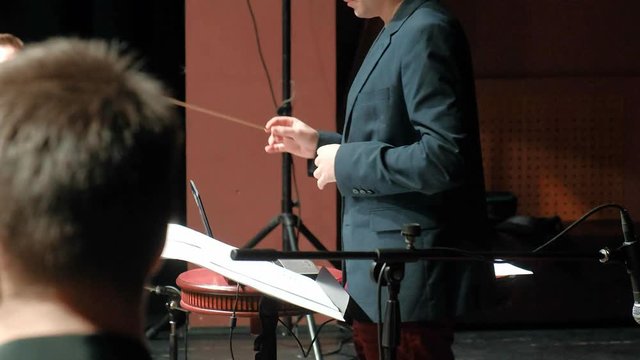 conductor of the symphony orchestra performs in a large hall