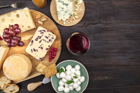 Various types of cheese with wine on a rustic background