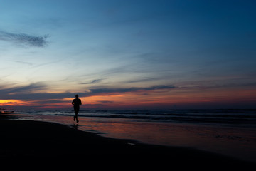 Silhouette of running man at sunset on the sea