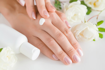 Beautiful groomed woman's hands applying moisturizing cream. Cares about clean, beautiful and soft hands skin. Manicure and pedicure beauty salon. Healthcare concept.