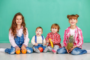 A group of children is sitting in a room. Useful Fruits. The concept of a healthy lifestyle, food, childhood, vitamins, vegetarianism.