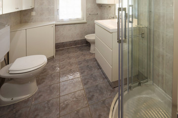 Bathroom with tiles and a large shower.
