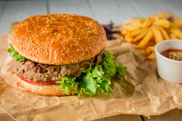 Big tasty burger with beef, salad, sauce and tomato.