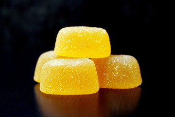 Marmalade. Lemon marmalade. Lemon juice. Gentle taste. Lemon marmalade. Slices of lemon marmalade in sugar on a dark background.