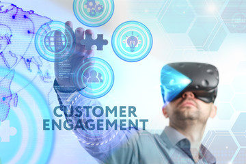 Business, Technology, Internet and network concept. Young businessman working in virtual reality glasses sees the inscription: Customer engagement