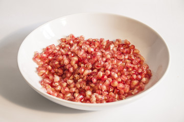 Close up Pomegranate Seeds in Plate, isolated
