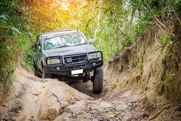 4 wheel drive is climbing on a difficult off-road in mountain forests in Thailand.