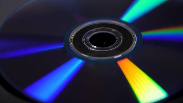Compact disk isolated on black background. Abstract macro close up of colorful rainbow reflection from compact disc. Colorful abstract background. Rainbow on CD