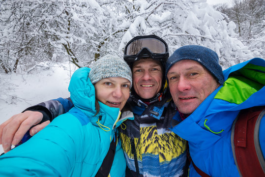 Company of happy friends makes selfie after freeride