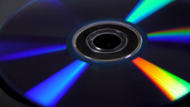 Compact disk isolated on black background. Abstract macro close up of colorful rainbow reflection from compact disc. Colorful abstract background. Rainbow on CD