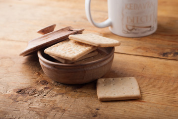 Homemade crispy crackers in a rustic wooden bowl,